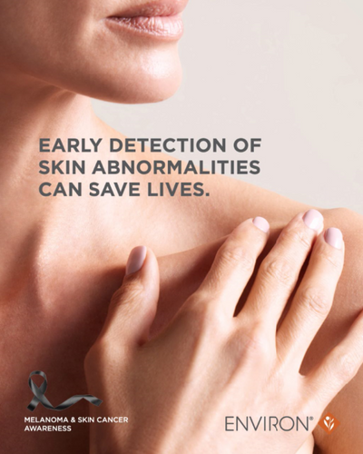 A soft-focus close-up of a woman’s shoulder and hand with light pink nail polish, gently touching her skin.