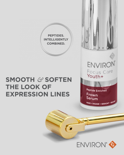 Silver and maroon environ focus care youth+ peptide enriched frown serum bottle with a gold-toned roller device beside it.
