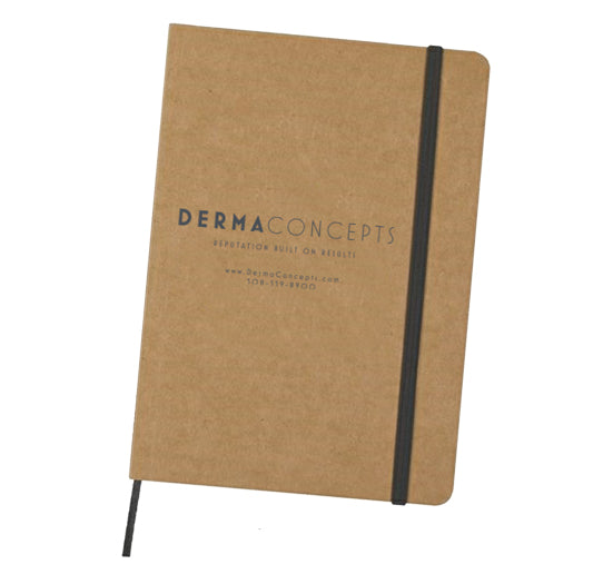 A brown DermaConcepts branded notebook features a black elastic closure band and matching ribbon bookmark.