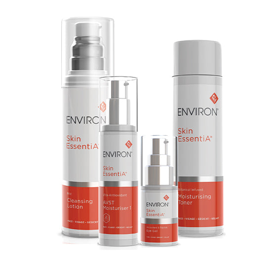 Four white and orange Environ Skin EssentiA skincare products, including a cleanser, AVST moisturiser, eye gel, and toner, stand together to form a complete daily routine.